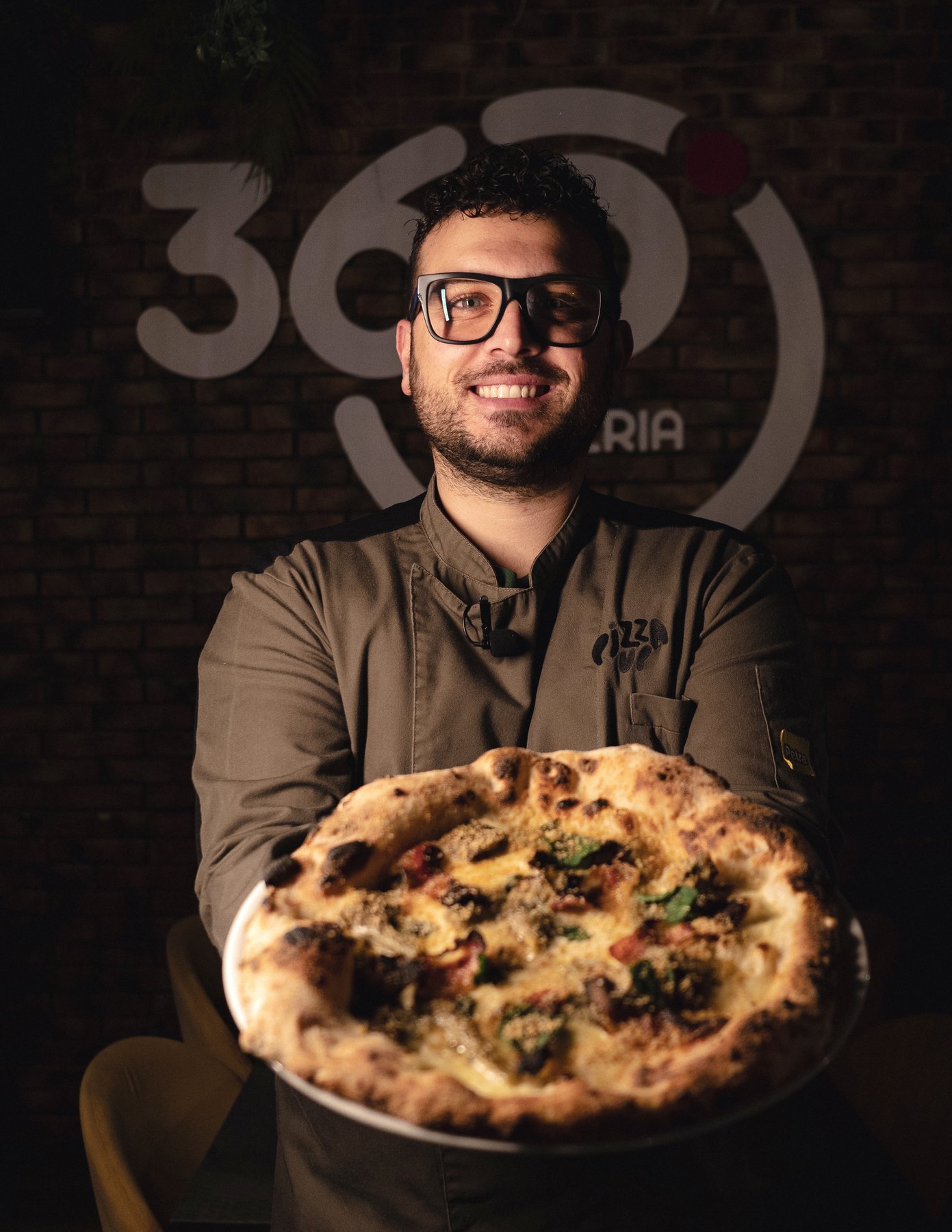 Giuseppe Schembri con pizza davanti al logo 360 Gradi